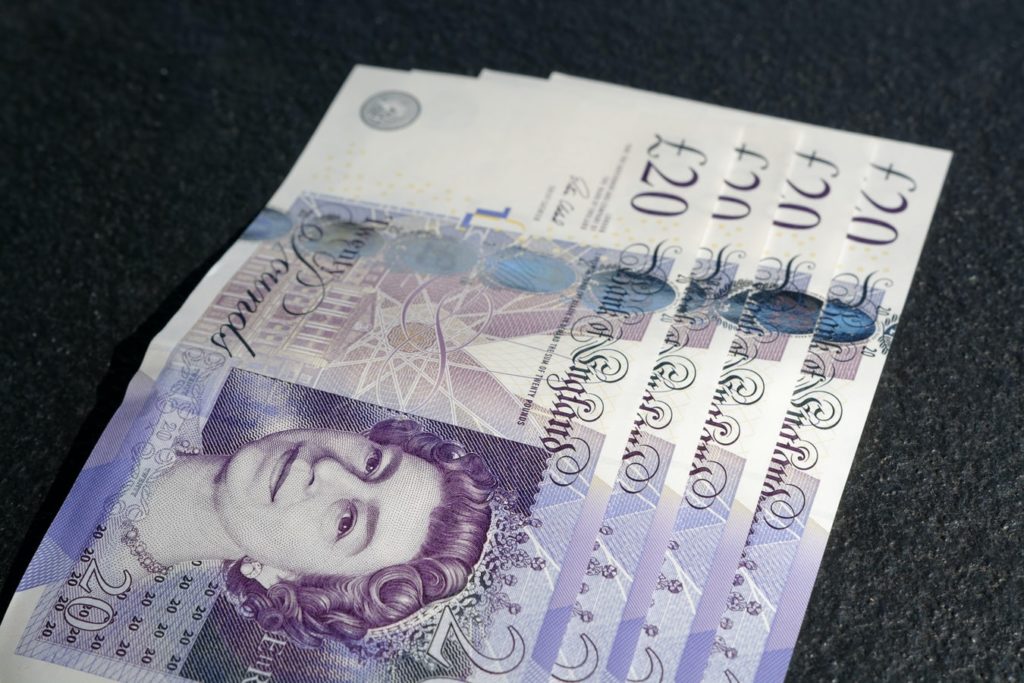 Four £20 notes arranged in a line